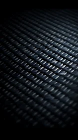 Carbon fiber weave surface under raking light, macro study.