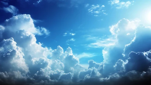 Towering sunlit clouds rise into a radiant blue sky.