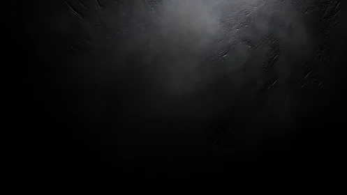 Dark textured surface with subtle foggy light gradient.