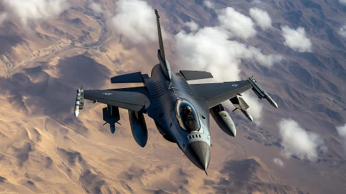 Fighter jet flies above desert terrain with scattered clouds