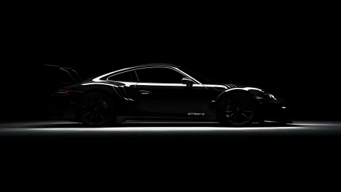 Low-key side profile of black GT sports car in shadows.