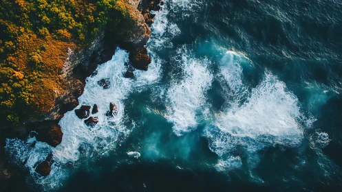 Waves crash against rugged cliffside in dramatic aerial view.