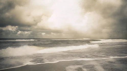 Moody waves roll beneath a softly glowing storm sky