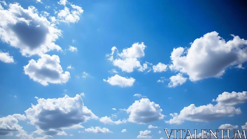 Soft white clouds drift across a calm, radiant blue sky