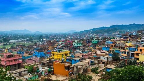 Vibrant hillside settlement under expansive blue sky panorama.