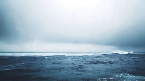 Moody open ocean under heavy mist and pale sky.