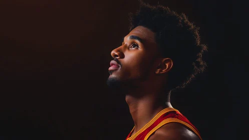 Basketball player profile under dramatic studio spotlight.