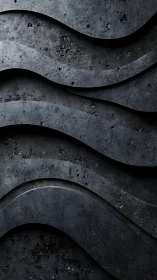 Layered graphite waves form a sculpted industrial relief