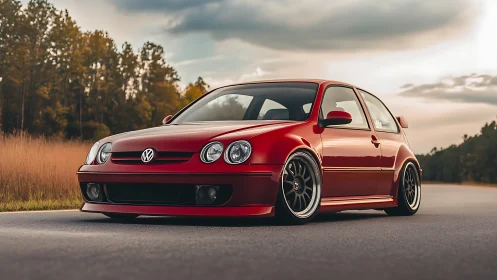 Scarlet VW hatchback lounges low beneath a moody horizon
