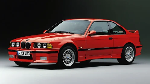 Red BMW E36 coupe studio shot with classic body styling.