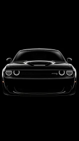 Front silhouette of black muscle car in dramatic lighting.