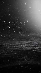 Monochrome high-contrast water surface with suspended illuminated droplets