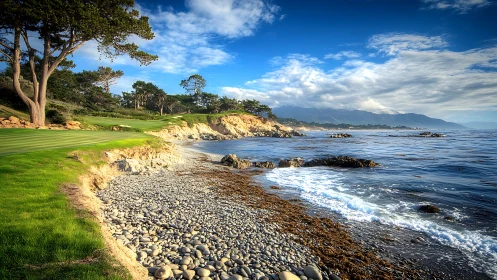 Rocky shoreline meets lush coastal golf course at sunrise.