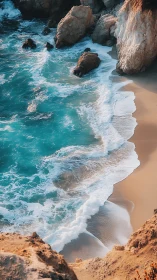 Coastal shoreline with waves, sand, and rocky cliff face.
