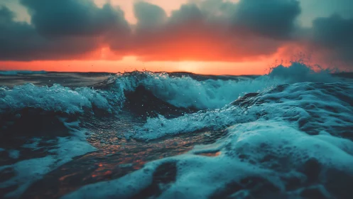 Stormy teal ocean waves under intense red sunset sky.