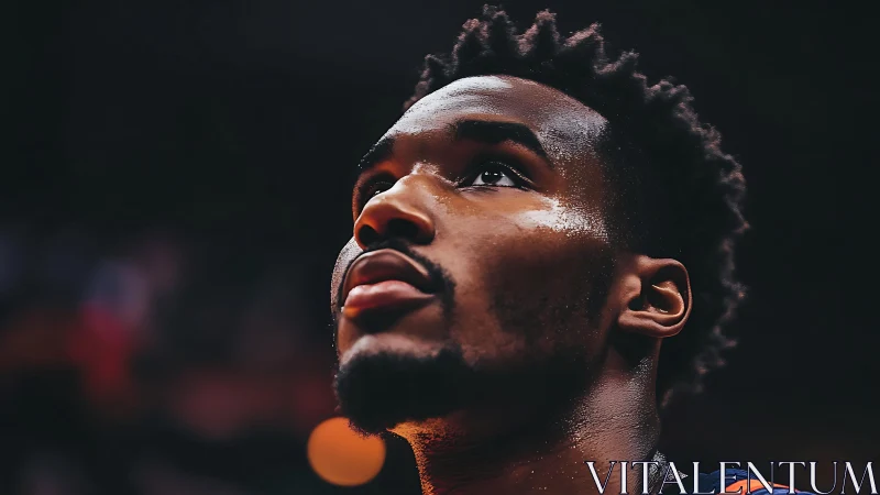 Basketball player gazes upward under arena lights before game