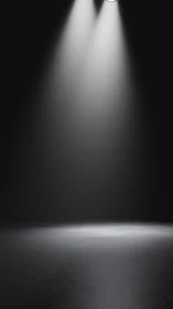 Twin spotlights cast dramatic beams onto empty floor.