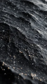 Dark wet rock surface catches drifting coastal spray.