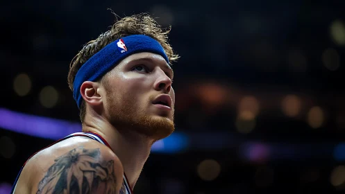 Male basketball player with headband in arena setting.