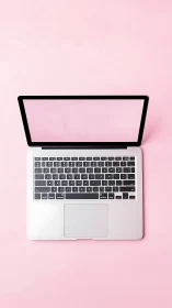 Laptop lounges confidently on a sugar-pink creative stage