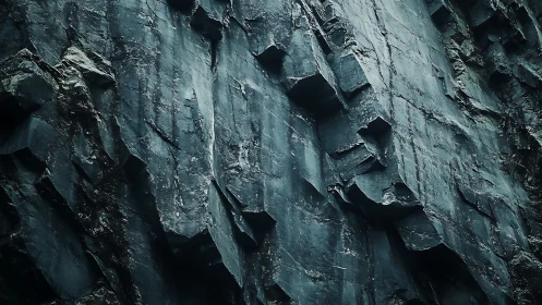 Angular basalt cliff face with fractured columns and cool tonal contrast