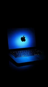 Glowing blue laptop with illuminated keyboard in darkness.