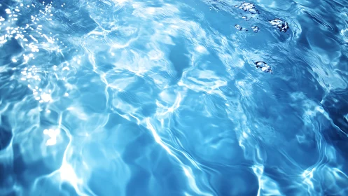 Sunlit blue water surface shows ripples and air bubbles
