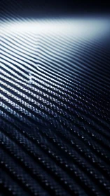 Carbon fiber surface with directional light reflections.