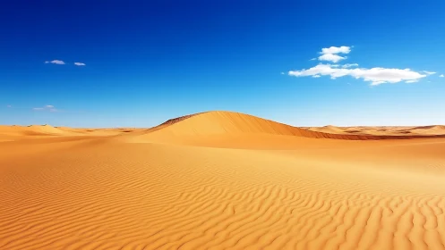 Golden desert dune under deep cobalt sky at midday.