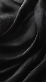 Textural study of black draped fabric with directional sheen.