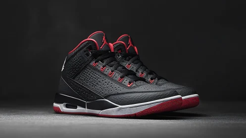 Black and red mid top basketball sneakers on dark background.