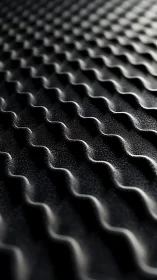 Rippled graphite waves in a shadow-soaked geometric landscape.