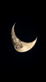 Sharp crescent moon close up in dark night sky.
