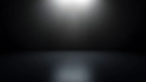 Soft spotlight over quiet dark stage of open possibilities.