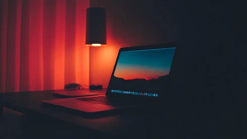 Midnight laptop glow bathing a quiet desk in ember calm.