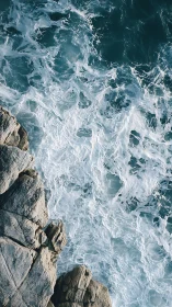 Aerial littoral interface of surf turbulence and coastal rock mass.
