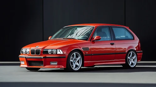 Red BMW hatchback in glossy studio light on dark backdrop.