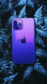 Violet gradient iPhone gleams amid midnight blue foliage.