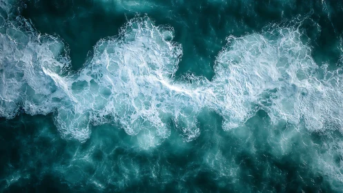 Seafoam ribbons drifting over deep teal rolling water.