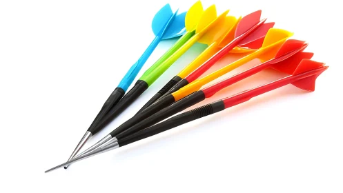 Colorful plastic darts lie fanned on white reflective surface