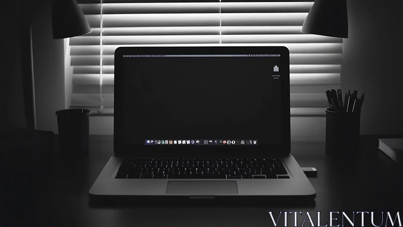 Quiet laptop glow in a calm monochrome home workspace.