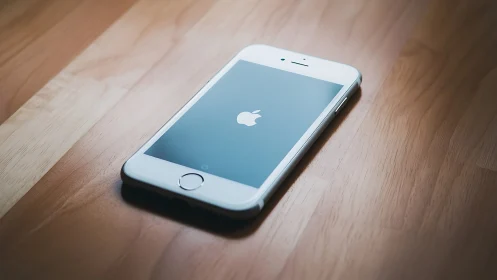 White iPhone 5s on Natural Wood Surface with Illuminated Display