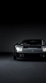 Black sports car front view in dark minimal studio.