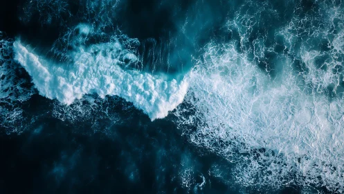 Aerial view shows foaming ocean waves in deep blue water.