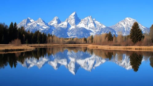 Snowcapped mountain range mirrored in tranquil lake panorama.