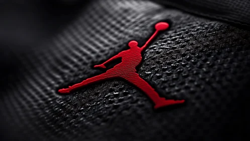 Red basketball silhouette pops on textured black fabric.