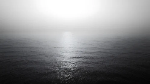 Minimalist seascape under bright fog-shrouded horizon.