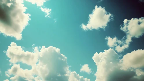 Sunlit cumulus clouds drift gently across a tranquil sky