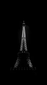 Monochrome Eiffel Tower silhouette under dramatic night lighting.