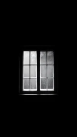 Solitary rainlit window carving silence from the dark.